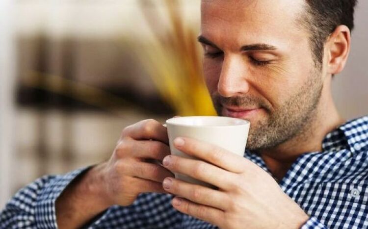 A man drinks a drink of fireweed tea to increase strength